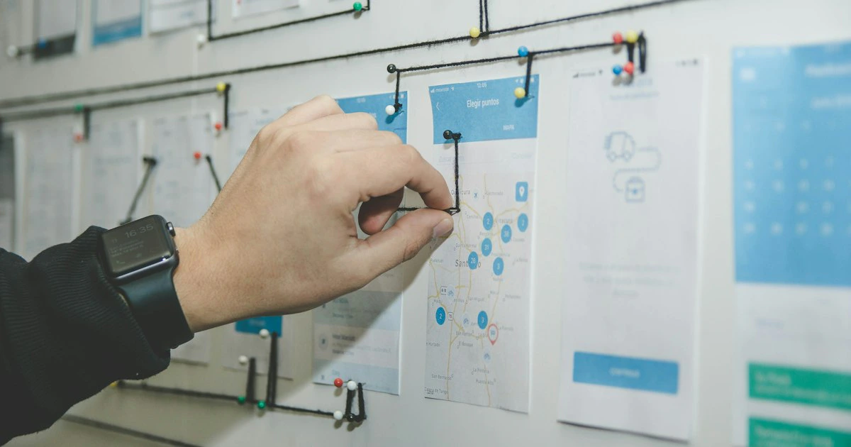 Persona organizando ideas y notas adhesivas en una pizarra para planificar contenido