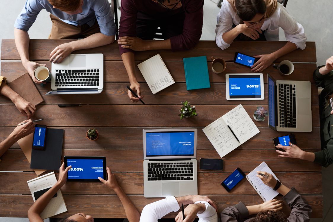 Equipo de trabajo colaborando frente a una laptop para analizar datos en una oficina